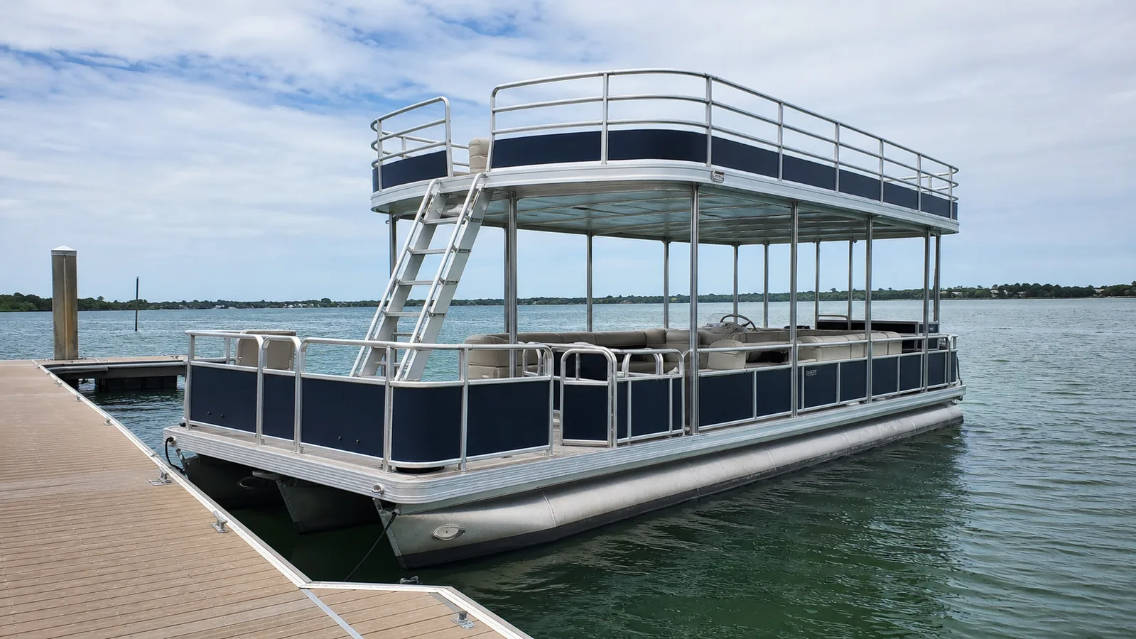 Unbranded double-decker pontoon boat at a resort marina